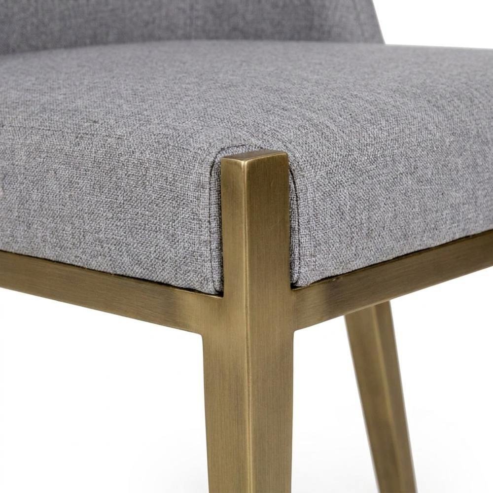 Modern grey and brass dining chair with padded seat and sleek design
