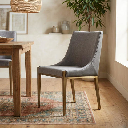 Modern grey and brass dining chair with padded seat and sleek design